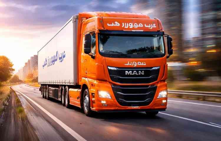 شاحنة نقل عفش برتقالية حديثة تابعة لشركة عرب موورز ہب تسير بسرعة على طريق المدينة ضمن خدمات شركه نقل عفش بخميس مشيط الاحترافية.