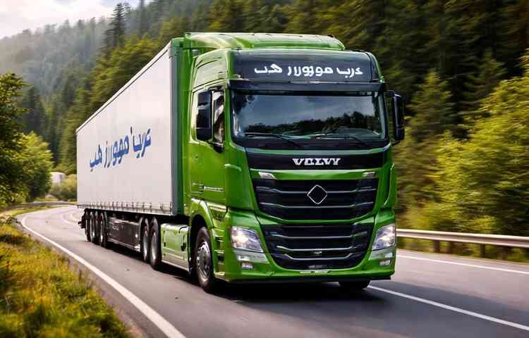 شاحنة نقل عفش خضراء حديثة تابعة لشركة عرب موورز ہب تسير على طريق تحيط به الغابات ضمن خدمات شركه نقل عفش بخميس مشيط لنقل الأثاث بأمان.