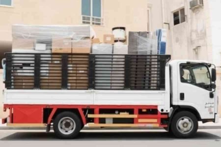 شاحنة نقل محملة بالأثاث المغلف أمام مبنى سكني – عرب موورز ہب شركه نقل عفش بالدمام