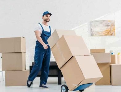 عامل نقل عفش يستخدم عربة يدوية لنقل الصناديق داخل منزل حديث مع خدمة احترافية من عرب موورز ہب لنقل الأثاث بسرعة وأمان
